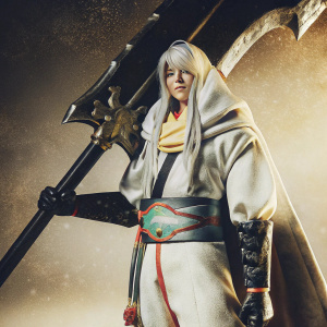 Digital artwork featuring Ellenai Kesia, a youthful, Caucasian character, in an anime-inspired fantasy setting. Long, white hair flowing, adorned in a pristine white ensemble, accented with black and vibrant hues. Equipped with a massive, ornate black weapon, adorned in gold. Set against a serene, muted brown backdrop, the illustration adopts a sleek, contemporary aesthetic.