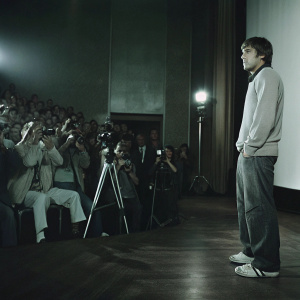 Fernando Alonso, in casual attire, at a press conference. Large audience and cameras present
