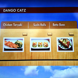 The Dango Catz food truck menu showcases a variety of Japanese-inspired dishes. The menu's warm color palette features shades of brown, creating an inviting atmosphere. It includes items like chicken teriyaki, sushi rolls, and bento boxes. The layout is neatly organized, with main categories listed at the top and individual dishes detailed below, accompanied by appetizing images.