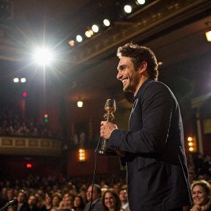 James Franco accepting an award. Shining smile. Crowded auditorium. Bright spotlights