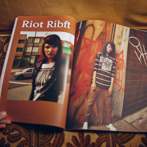A feature page in a lifestyle magazine, highlighting streetwear brand 'Riot Ribft'. The spread includes vibrant images of a young Asian model sporting the brand's t-shirt, set against an urban backdrop.