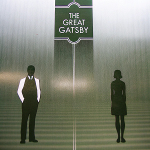 Minimalist cover design for 'The Great Gatsby'. Art Deco inspired. Dark green and black color palette. Silhouette of man in suit and woman in vintage dress.