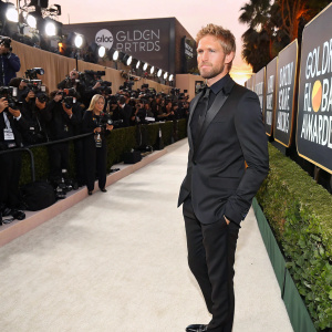 Matt Barr, in a sleek black suit, at the Golden Globe awards. White carpet, flashing cameras, paparazzi swarm