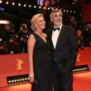 Sabine Christiansen and Norbert Medus at Berlinale. Sabine wears an elegant black evening gown, Norbert in a classic tuxedo. Flashing lights from paparazzi