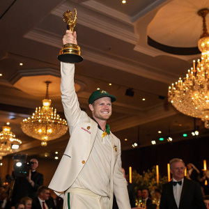 Steve Smith, a cricket star, in a victory pose. Golden statue in hand, celebrating at a gala. Chandeliers and elite guests around.