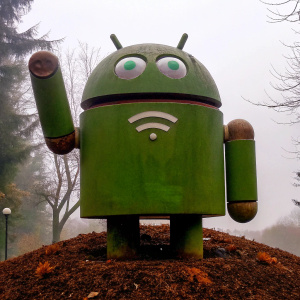 Cartoonish android mascot waving hello. Green body with Wi-Fi icon. Simple design on white backdrop.
