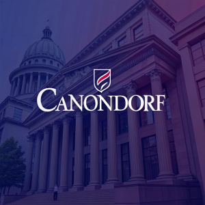 Abstract logo of 'CanonDorf' in sleek, contemporary font. Set against a deep indigo background with hints of burgundy.