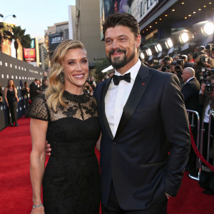 Katee Sackhoff and Karl Urban at the premiere of Star Trek Beyond. Both are dressed formally. Katee in a black lace dress, Karl in a tuxedo. Red carpet event with photographers and fans in the background.