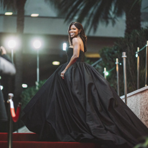 Serena Williams at a glamorous awards ceremony. Wearing a black evening gown, posing on a red carpet.