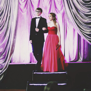 Isaac Hempstead Wright and Helen Wright at the star-studded movie gala. Formal evening wear. Golden curtains backdrop