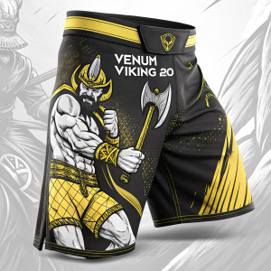 High-resolution image showcasing the Venum Viking 2.0 fight shorts. The shorts are predominantly black with vibrant yellow accents. The design features a fierce viking warrior wearing a helmet and wielding an axe, his expression stern and focused. The Venum logo is prominently displayed above the waistband.
