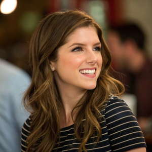 Anna Kendrick, beaming with a warm smile. A candid shot with soft focus blurring out the background.
