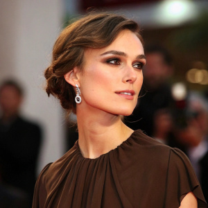 Close-up of Keira Knightley. She is at a gala event. Wearing a brown blouse with short hair.