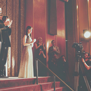 Alexis Bledel at the GLAAD Media Awards, standing on stage. Surrounded by applause and flashing cameras.