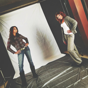 Micaela Schaefer and Patricia Blanco, posing confidently on a stark white backdrop. They are dressed in casual attire.