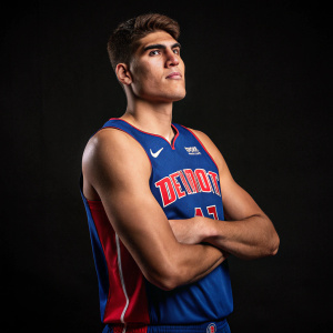 Professional portrait of Luka Garza, basketball player. Wearing Pistons jersey. Confident pose. Dark background