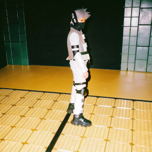 3D render of a futuristic Kakashi Hatake inspired character. Character stands on a neon-lit, metallic floor in a high-tech setting. Dark, sleek background with neon accents.