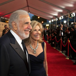 Carl Icahn and Gail Icahn, smiling at a fundraising gala. Red carpet event with flashing cameras and crowd.