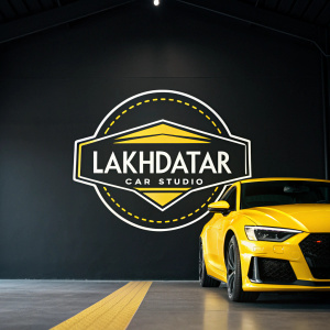 Lakhdatar Car Studio logo in a vibrant photo. Yellow and white hues on black background, sleek and modern design