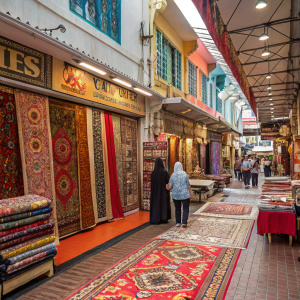 A bustling carpet store on Arab Street, Singapore. Colorful and patterned carpets fill the shop.
