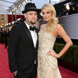 Benji Madden and Paris Hilton at a glamorous awards show. Benji in a black tuxedo and top hat, Paris in a stunning evening gown.