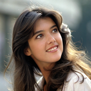 Close-up portrait of Phoebe Cates. Soft, warm smile. Light makeup, long wavy hair