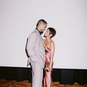 Shemar Moore and Halle Berry at an awards ceremony, standing close together against a plain black backdrop.