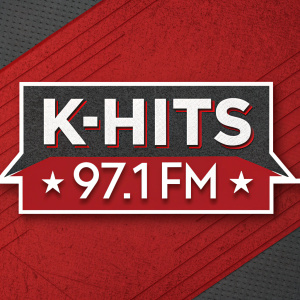 A digital illustration for the K-Hits 97.1 FM radio station. The design features bold, graphic elements with a mix of red and gray colors. The call letters and format identifier are prominently displayed against a bold, textured red background.