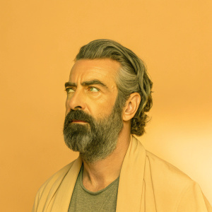Close-up portrait of Al Pacino. Intense expression, full beard and mustache, graying hair, against blurred background.