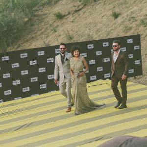 Cast of Preacher Season 2 at a gala event. Joseph Gilgun, Ruth Negga, and Dominic Cooper posing for photographers. Black backdrop with white AMC logo