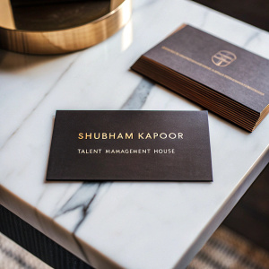 Business cards for Shubham Kapoor, entrepreneur of Talent Management House. Luxurious black and gold theme, laid out on white marble table.