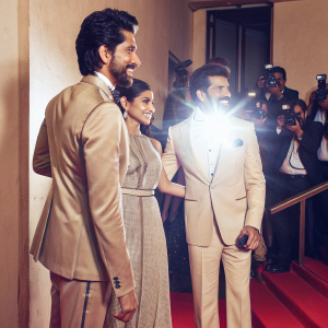 Dev Patel, Freida Pinto, and Anil Kapoor at the premiere event. Wearing designer suits and elegant dresses. Crowded red carpet with flashing cameras.
