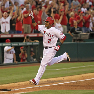 Erick Aybar sprinting towards home plate. Angels jersey, number 2 visible. Spectators cheering in the background.