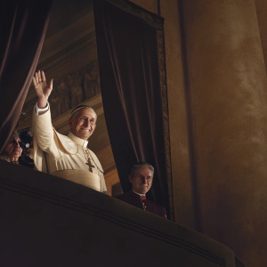 Pope waving to the crowd from the balcony of St. Peter's Basilica, wearing papal attire, smiling warmly.