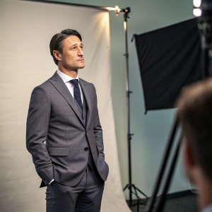 Niko Kovac, football coach, in an interview setting. Wearing a grey suit and tie. Studio backdrop