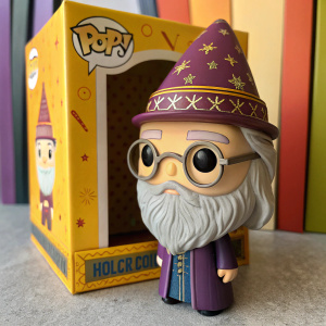 Albus Dumbledore Funko Pop figure inside a themed packaging. Detailed wizard hat and face features. Bright packaging design