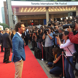 Matthew McConaughey, wearing a blue blazer and khakis, at the Toronto International Film Festival premiere for 'Gold'. Crowded red carpet scene, photographers in the foreground