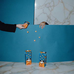 Creative ad showcasing Citiri's snack range. White marble backdrop. Bright, playful packaging with cartoon characters. Vibrant colors like blue and orange. Different sizes and shapes of snack packages.