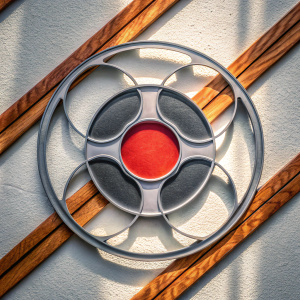 Reelz Studio logo showcasing a modern, sleek design element reminiscent of a film reel, set against a crisp white backdrop with a prominent red circle at the center.