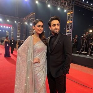 Imran Khan and Kareena Kapoor Khan at a glitzy award ceremony. Both dressed in formal attire, Imran in a suit, Kareena in a dazzling sari.