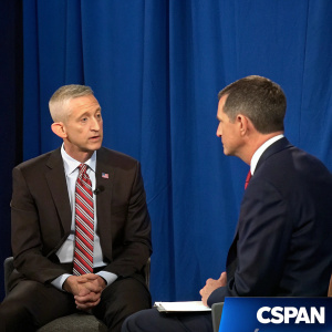 Trey Gowdy and Peter Strzok appearing on a live C-SPAN broadcast. Both are seated in front of a plain blue backdrop