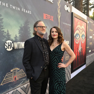 Clark Middleton and Elissa Middleton at a premiere event for Twin Peaks. They stand before a backdrop filled with surreal imagery and logos.
