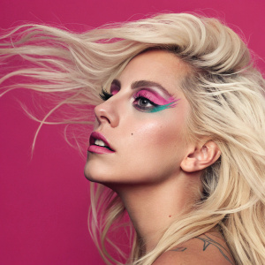 Lady Gaga's ARTPOP album cover. Vibrant pink backdrop, close-up of Lady Gaga's face with intricate makeup. One side features a detailed hand holding her hair