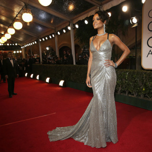 Rihanna at the Golden Globe Awards. Wearing a striking silver sequined gown with a plunging neckline and dramatic train.