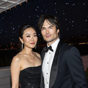 Yunjin Kim and Ian Somerhalder attend the MET Gala. Both are dressed in formal attire. Dark, starry night background with city lights