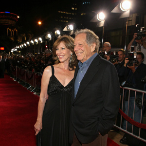 Elizabeth Segal and George Segal attending the star-studded opening night of 'The Duchess and the Dirtwater Fox' premiere. A sea of photographers and fans in the background.
