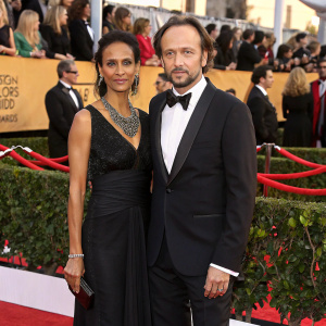 Vincent Perez and Karine Silla at a glamorous awards show. Dressed in formal attire, they stand out against a sea of red carpet attendees.