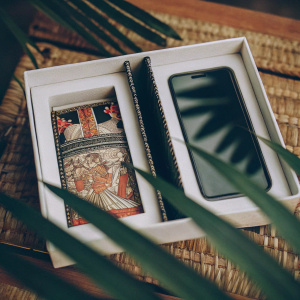 Karbonn Mobiles' sleek white packaging featuring vibrant colors and traditional art forms. The phone display showcases multilingual support.