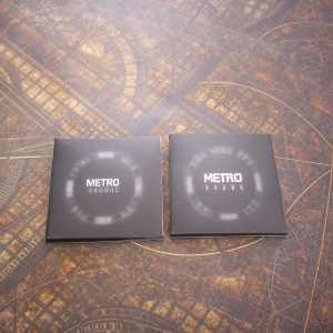 Two sleek, metallic disc packages for the game 'Metro: Exodus', designed with a dark and futuristic theme.