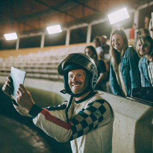 Dale Earnhardt Jr., the NASCAR driver, signing autographs and posing for photos with fans in the grandstands.